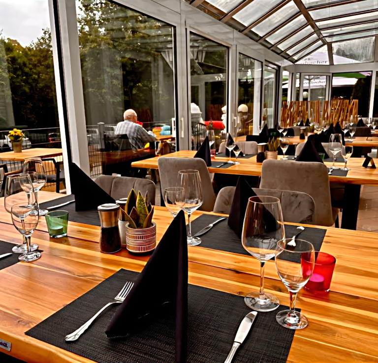 Gedeckte Tische im Wintergarten